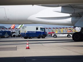 A Brinks security van beside a Boeing Co 777 passenger plane.