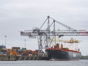 Un porte-conteneurs est chargé dans le port de Montréal.  La Voie maritime du Saint-Laurent a fermé ses portes après que des centaines de travailleurs ont débrayé tôt dimanche en raison de l'échec des négociations contractuelles.