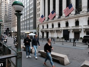 Pedestrians walk by the New York Stock Exchange.