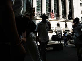 People walk past the New York Stock Exchange.