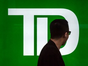 A pedestrian walks past a TD Bank sign in Toronto.