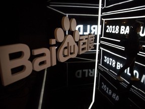 FILE - An attendee walks past a display at the Baidu World conference in Beijing, on Nov. 1, 2018. Chinese search engine and artificial intelligence firm Baidu on Tuesday, Oct. 17, 2023, unveiled the latest version of its artificial intelligence model Ernie 4.0, claiming that it rivals models such as GPT-4 in the U.S