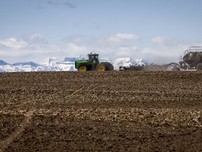L'Institut canadien des politiques agroalimentaires recommande que les gouvernements de tout le pays élaborent et publient un plan national pour gérer et utiliser de manière durable l'eau pour le secteur agroalimentaire.  Une famille plante sa récolte de blé avec un appareil de semis, près de Cremona, en Alberta, le vendredi 6 mai 2022.