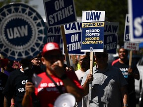 Labour supporters and members of the United Auto Workers union (UAW) Local 230 march along a picket line during a strike outside of the Stellantis Chrysler Los Angeles Parts Distribution Center in Ontario, Calif., on Sept. 26, 2023.