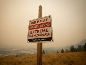 A warning sign about fire risk is seen as smoke from wildfires fills the air, in Kelowna, B.C., in August. KPMG says businesses must make climate risk a priority amid changing weather patterns.