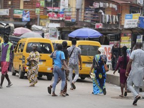 Pedestrians cross a busy streets in Lagos, Nigeria, Tuesday Sept. 5, 2023.