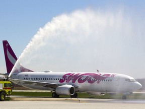 A firetruck salutes a Swoop Airlines Boeing 737 that landed in London, Ont., from Edmonton as the inaugural flight of the budget airline. The operation has since been absorbed into WestJet.