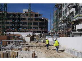 Workers carry a platform through the site of a residential construction site operated by Neinor Homes S.L.U. in the San Sebastian de los Reyes district of Madrid, Spain, on Wednesday, March 8, 2017. Neinor Homes, bought in 2014 by the Dallas-based investor Lone Star Funds, aims to become one of Spain's biggest homebuilders by increasing construction in big cities where the housing stock is running low, according to Chief Executive Officer Juan Velayos. Photographer: Angel Navarrete/Bloomberg