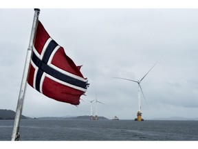 A Norwegian flag flies from a boat near the assembly site of offshore floating wind turbines in the Hywind pilot park, operated by Statoil ASA, in Stord, Norway, on Friday, June 23, 2017. The world's first offshore floating wind farm will be moved to its final destination outside Peterhead, Scotland, later this summer to provide clean energy to 20,000 British households.