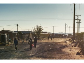 Pedestrians make their way down a dusty road in a township outside Brandfort, South Africa, on Tuesday, June 5, 2018. More than 60 percent of the 257 municipalities are categorized as dysfunctional or almost dysfunctional, according to the Co-operative Governance Ministry.