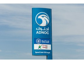 A sign outside an Abu Dhabi National Oil Co. (ADNOC) gas station in the Jebel Ali Industrial district of Dubai, United Arab Emirates, on Thursday, April 20, 2023. Abu Dhabi's main energy company ADNOC raised $2.5 billion from the initial public offering of its gas business, pulling off the year's biggest listing and continuing a trend that saw the Middle East emerge as a bright spot for share sales in 2022. Photographer: Christopher Pike/Bloomberg