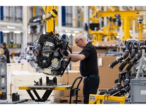 An employee works on the range extender motor of a TX electric London black cab at the London EV Co. (LEVC) manufacturing plant in Coventry, UK, on Thursday, May 4, 2023. The Coventry factory produced its 10,000th car in March, more than five years after shipping its first electric taxi with a range-extending small engine.
