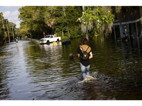 Residents walk through a flooded street after Hurricane Idalia made landfall in Cristal River, Florida, US, on Wednesday, Aug. 30, 2023. Hurricane Idalia knocked out power to hundreds of thousands of Florida customers, grounding more than 1,800 flights and unleashing floods along far from where it came ashore as a Category 3 storm earlier Wednesday.