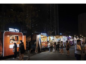 Customers order from food trucks at an outdoor food park at night in Mandaluyong City, Manila, the Philippines, on Friday, Oct. 6, 2023. Rice inflation in the Philippines soared to a 14-year high in September, indicating limited impact of President Ferdinand Marcos Jr.'s price cap on the staple grain.