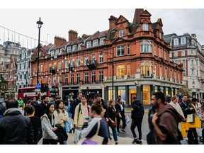 Shoppers cross a road among the shops on Oxford Street in central London. Photographer: Jose Sarmento Matos/Bloomberg