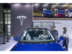 A visitor tries out a Model Y car at the Tesla Inc. booth during the World Internet of Things Exposition in Wuxi, China, on Saturday, Oct. 21, 2023. The show runs through Oct. 23.