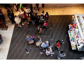 Shoppers wait in line outside a store at the Polaris Fashion Place mall in Columbus, Ohio.