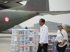 Indonesian President Joko Widodo, left, and Foreign Minister Retno Marsudi inspect the relief supplies for Palestinians in Gaza, before its departure at Halim Perdanakusuma air base in Jakarta, Indonesia, Saturday, Nov. 4, 2023.