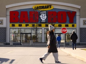 People walk past a Bad Boy furniture store in Brampton, Ont. on Monday, Nov., 13, 2023.
