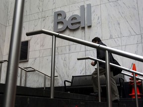 A pedestrian arrives at BCE Inc.'s Bell Canada office building in Toronto. BCE says it will cut capital spending by $1 billion after a CRTC ruling ordered it to open up broadband networks to smaller rivals.