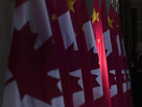 A Chinese flag illuminated next to Canadian flags in Ottawa. Over the past year alone, Canada has accused China of interfering in its domestic politics and criticized the Chinese military for flying dangerously close to its aircraft over the South China Sea.