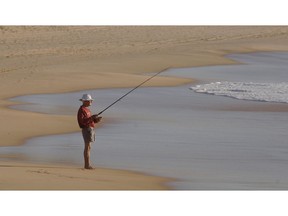 An elderly man fishes from the beach in Sydney. Australia's do-it-yourself pension plans are unique among developed nations.