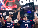 Montreal Alouettes quarterback Cody Fajardo (7) hoists the Grey Cup as fullback Alexandre Gagne (34) looks on as the Alouettes celebrate defeating the Winnipeg Blue Bombers in the 110th CFL Grey Cup in Hamilton, Ont., on Sunday, Nov. 19, 2023.