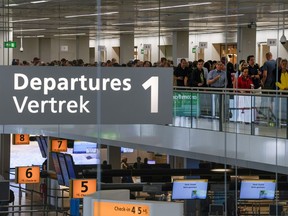 FILE - Travelers wait in long lines to check in and board flights at Amsterdam's Schiphol Airport, Netherlands, on June 21, 2022. The Dutch government has abandoned, for now, plans to rein in flights at Amsterdam's busy Schiphol Airport following protests from countries including the United States and warnings that the move could breach European law and aviation agreements.