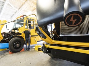 An employee assembles a school bus at Lion Electric's plant in Saint-Jerome, Que. The company cut 150 jobs.