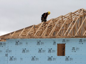 A construction worker working on a house in a new housing development in Oakville, Ont.