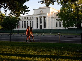 Pedestrians walk past the U.S. Federal Reserve in Washington, DC.