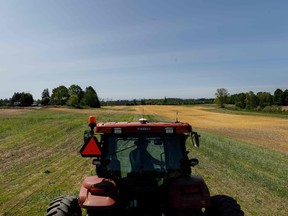 A farmer drives a tractor as he plants soybeans on his family's farm in Duffins Rouge Agricultural Preserve in Pickering, Ont.