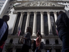 Pedestrians pass by the New York Stock Exchange in New York, U.S.