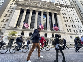 A man passes the "Fearless Girl" statue in front of the New York Stock Exchange in New York on Friday, November 3, 2023. Shares opened lower in Europe after a mixed day in Asia on Tuesday as investors waited for updates on inflation and how American consumers are feeling about the economy.