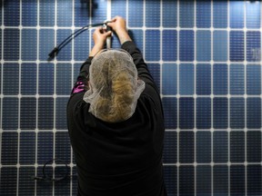 File - An employee works on a solar panel inside the Hanwha Qcells Solar plant on Oct. 16, 2023, in Dalton, Ga. On Wednesday, the Labor Department reports on job openings and labor turnover for September.