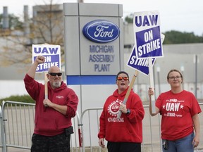 FILE - United Auto Workers members walk the picket line at the Ford Michigan Assembly Plant in Wayne, Mich., Sept. 26, 2023. Autoworkers at the first Ford factory to go on strike have voted overwhelmingly in favor of a tentative contract agreement reached with the company. Members of Local 900 voted 81% in favor of the four year-and-eight month deal, according to Facebook postings by local members on Thursday, Nov. 2, 2023.