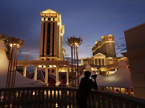 FILE - A man takes pictures of Caesars Palace hotel and casino in Las Vegas, Jan. 12, 2015. The Culinary Workers Union in Las Vegas has reached a tentative deal with casino giant Caesars Entertainment that could help avert a sweeping strike. The deal announced early Wednesday, Nov. 8, 2023, marks a major breakthrough after several months of unsuccessful negotiations.
