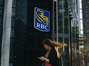 A woman walks past a Royal Bank of Canada sign in the financial district in Toronto on Tuesday, Sept. 20, 2022.