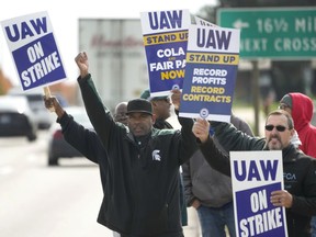FILE - United Auto Workers members walk the picket line during a strike at the Stellantis Sterling Heights Assembly Plant, in Sterling Heights, Mich., Monday, Oct. 23, 2023. A six-week United Auto Workers strike at Ford cut sales by about 100,000 vehicles and cost the company $1.7 billion in lost profits this year, Ford said Thursday, Nov. 30, 2023.