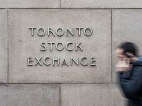 A man walks past the Toronto Stock Exchange on Bay Street in Toronto.