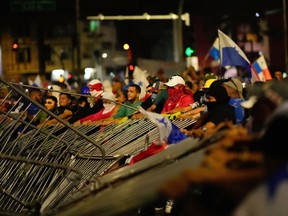 Demonstrators tear down a police barricade during a protest against a recently approved mining contract between the government and Canadian mining company First Quantum, in Panama City, Tuesday, Oct. 31, 2023.