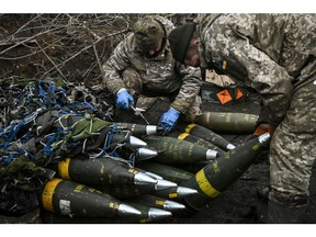 Ukrainian servicemen prepare artillery shells near Russian positions in the Bakhmut region. Photographer: Aris Messinis/AFP/Getty Images