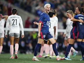 OL Reign forward Megan Rapinoe, center, reacts to a goal from teammate Veronica Latsko against Angel City FC during the second half of an NWSL quarterfinal playoff soccer match Friday, Oct. 20, 2023, in Seattle. The Reign won 1-0.