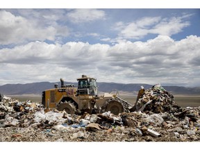 A worker operates a bulldozer to move trash at the Intermountain Regional Landfill in Fairfield, Utah, U.S., on Tuesday, June 30, 2020. Intermountain is working with Atlas ID, a software company that had focused on employment verification systems before the pandemic, to work out how often to test employees and in which scenarios. It'll cost about $2,000 a round. Photographer: Kim Raff/Bloomberg