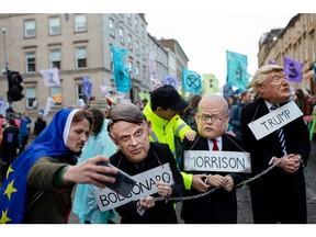 Demonstrators dress in the likeness of Jair Bolsonaro, Brazil's president, Scott Morrison, Australia's prime minister, and Donald Trump, former U.S. president, during a "Global Day of Action" protest on the sidelines of the COP26 climate talks in Glasgow, U.K., on Saturday, Nov. 6, 2021. Climate negotiators at the COP26 summit were banking on the worlds most powerful leaders to give them a boost before they embark on two weeks of fraught discussions over who should do what to slow the rise in global temperatures.