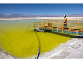 A mine supervisor inspects an evaporation pond of lithium-rich brine in the Atacama Desert in Salar de Atacama, Chile.  Photographer: John Moore/Getty Images