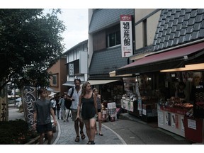 Visitors in front of a souvenir shop in Kanazawa. Photographer: Soichiro Koriyama/Bloomberg