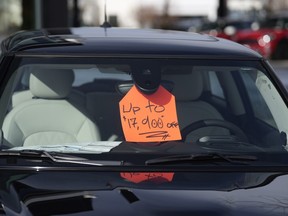A sign advertising a discount on an unsold 2024 Cooper SE electric hardtop at a Mini dealership in Colorado. EVs are sitting unsold at U.S. dealerships as buyers shy away from electric vehicles.