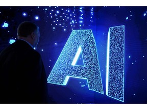 A visitor watches an AI (Artificial Intelligence) sign on an animated screen at the Mobile World Congress (MWC), the telecom industry's biggest annual gathering, in Barcelona. Photographer: JOSEP LAGO/AFP