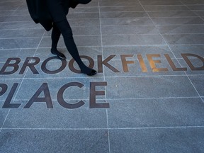 A pedestrian walks across footpath signage for the Brookfield Place Sydney office building in Australia.